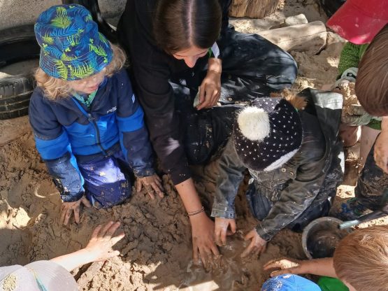 Lucía Ávila ensuciandose de barro con sus alumnos al aire libre